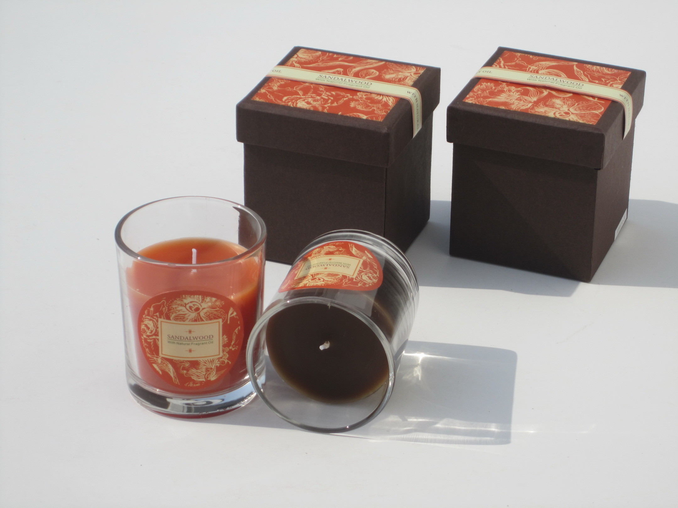 Orange & brown scented glass jar candle with printed label packed into gift box